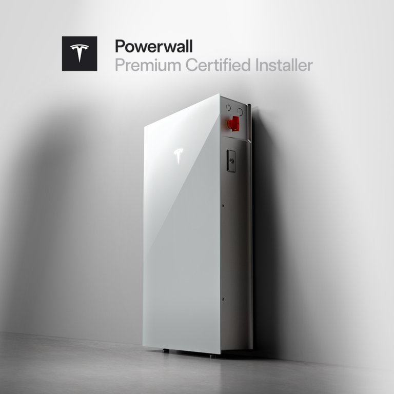 A Tesla Powerwall battery is mounted on a white wall with the Powerwall Premium Certified Installer logo displayed above it.