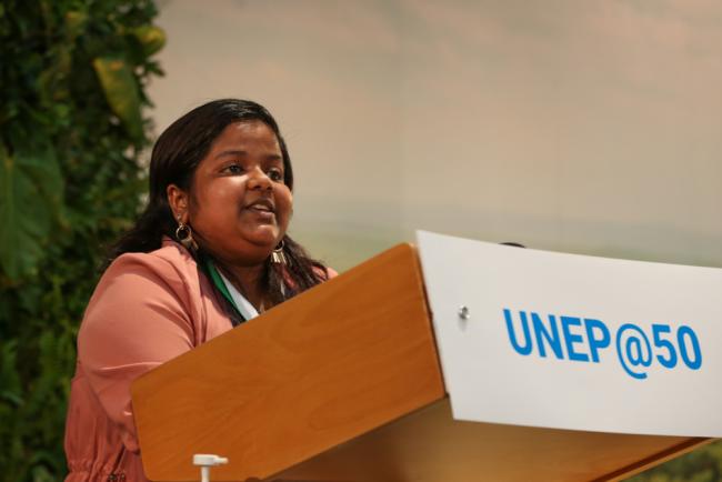 Yugratna Srivastava speaking at a lectern.