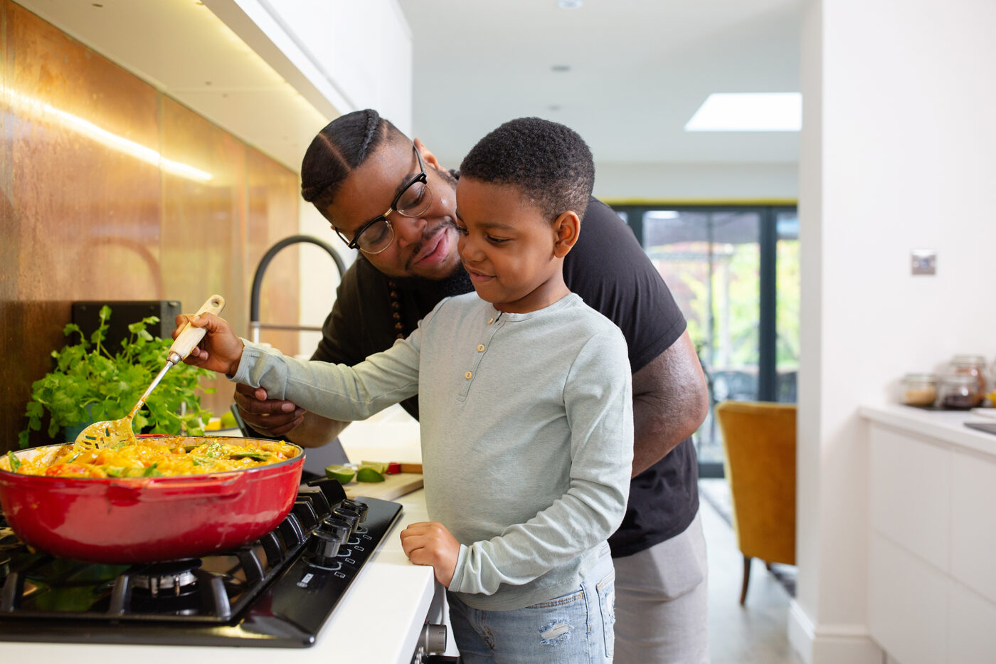 A father and son are cooking a vegetable curry together