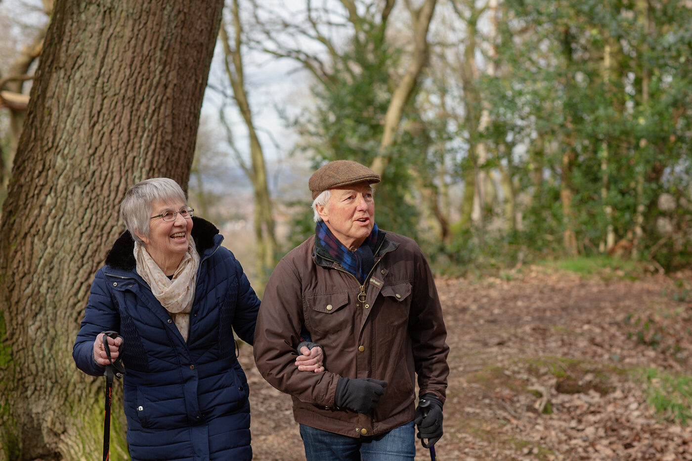 A retired couple go for a winter walk.